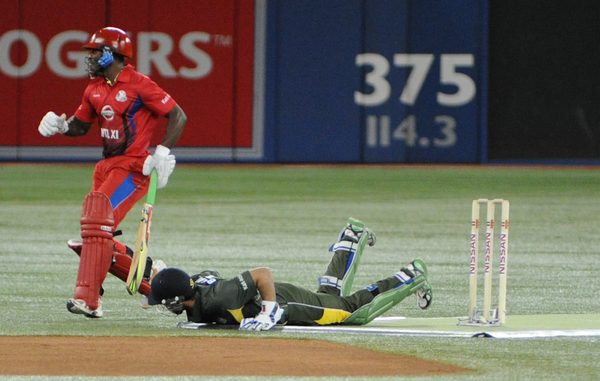 International XI batsman Devon Smith scrambles back as Asia/Canada wicket keeper lays on the ground after diving for a ball. Bagai was eventually able to stump Smith but not for the West Indies player hit for a match-high 69 runs to be named Man of the Match (Karan Vyas)